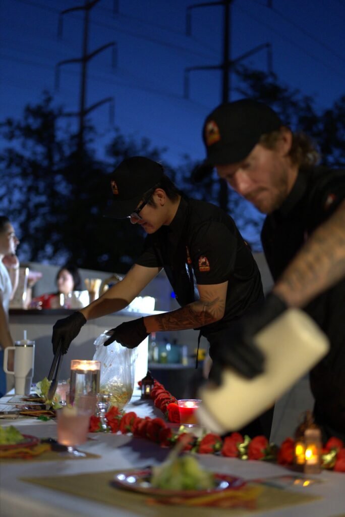 Hibachi chefs preparing and serving food at an outdoor evening party