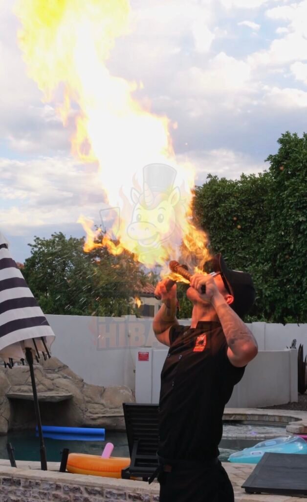 Hibachi chef breathing a tall flame beside a backyard pool