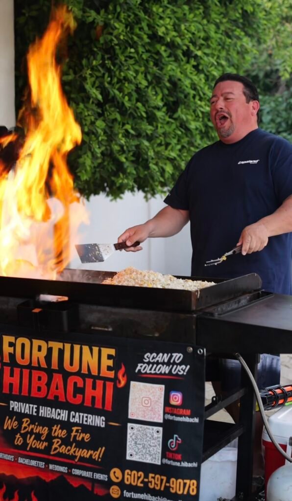 Hibachi chef cooking fried rice beside tall flames on the Fortune Hibachi grill