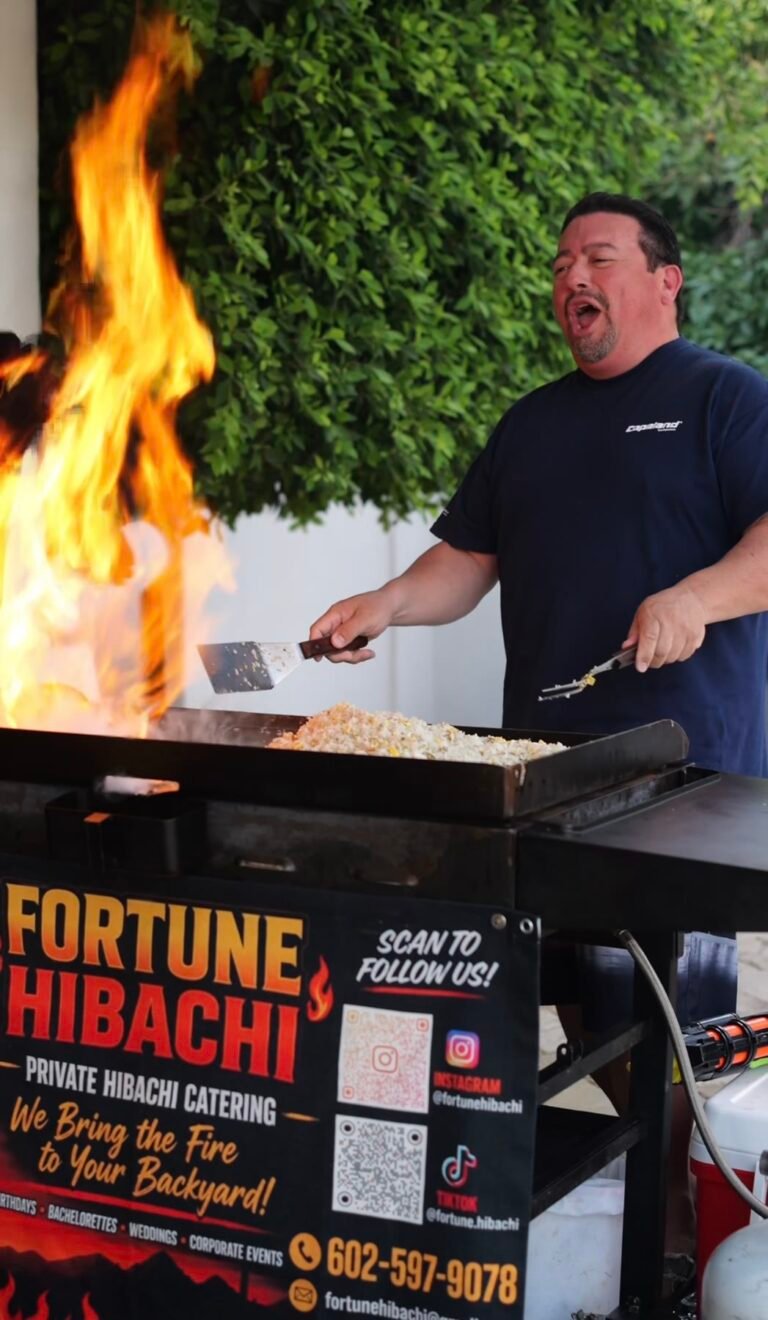 Hibachi chef cooking fried rice beside tall flames at an evening event