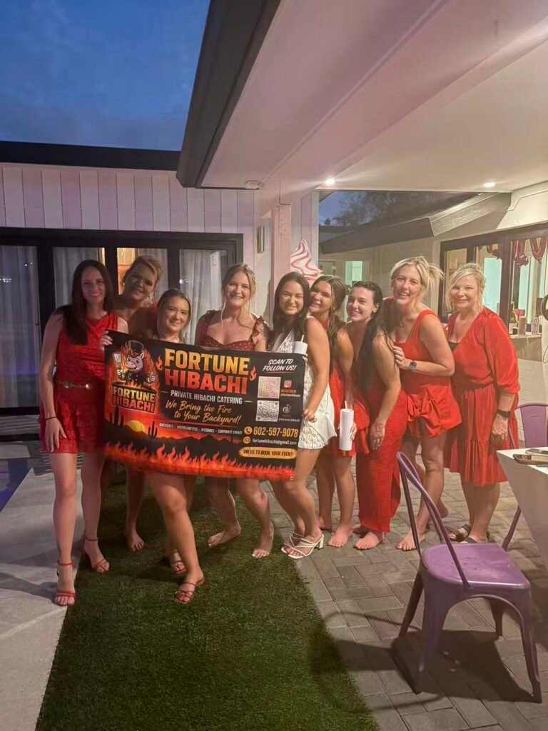 Guests holding a Fortune Hibachi banner at a backyard party