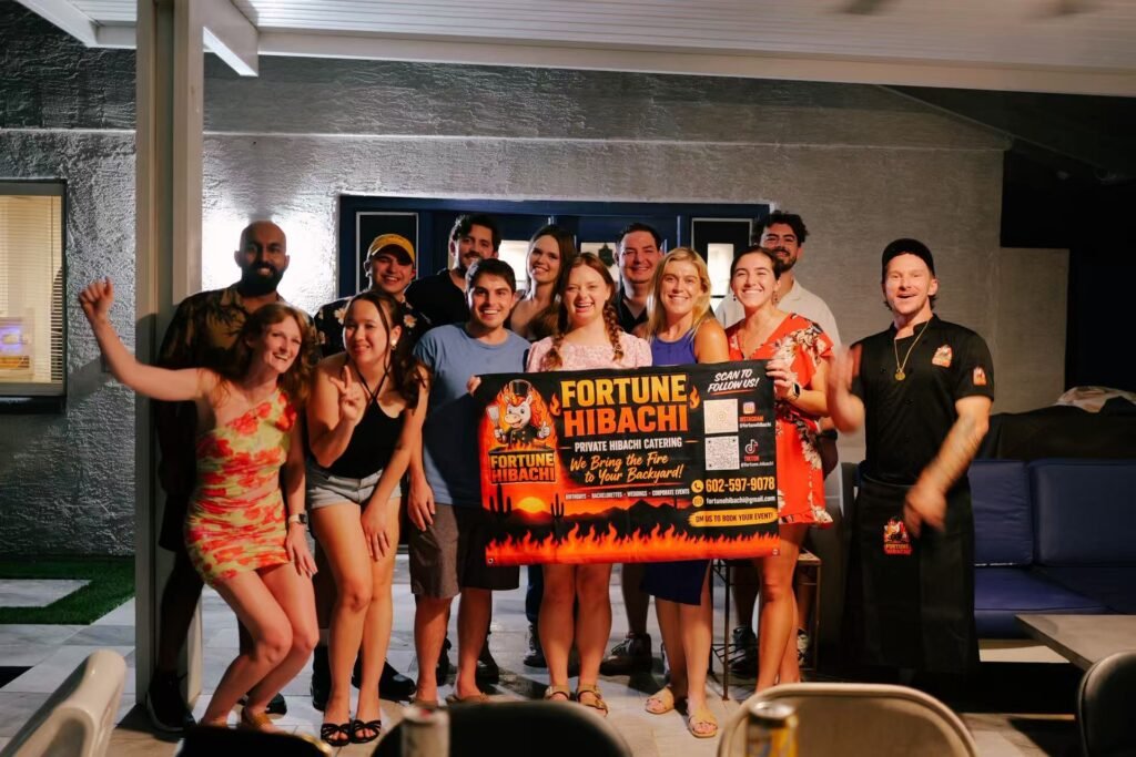 Fortune Hibachi chefs and guests posing with the party banner